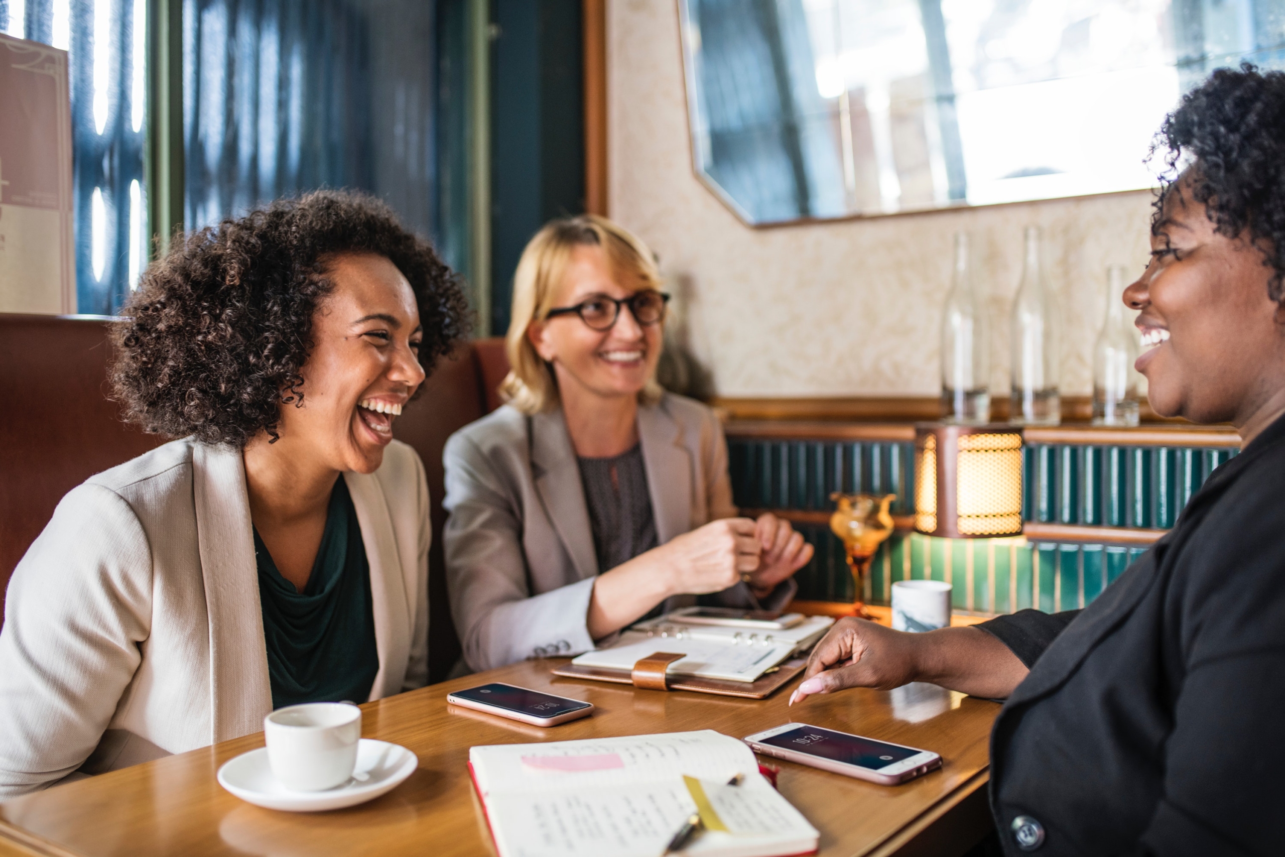 Three Business Women Laughing During a Meeting