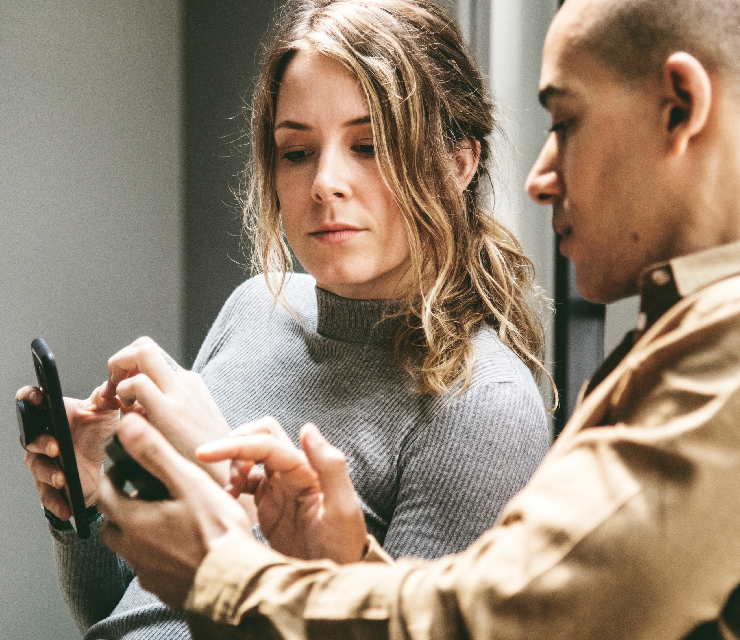 Man Showing Woman Information on His Phone