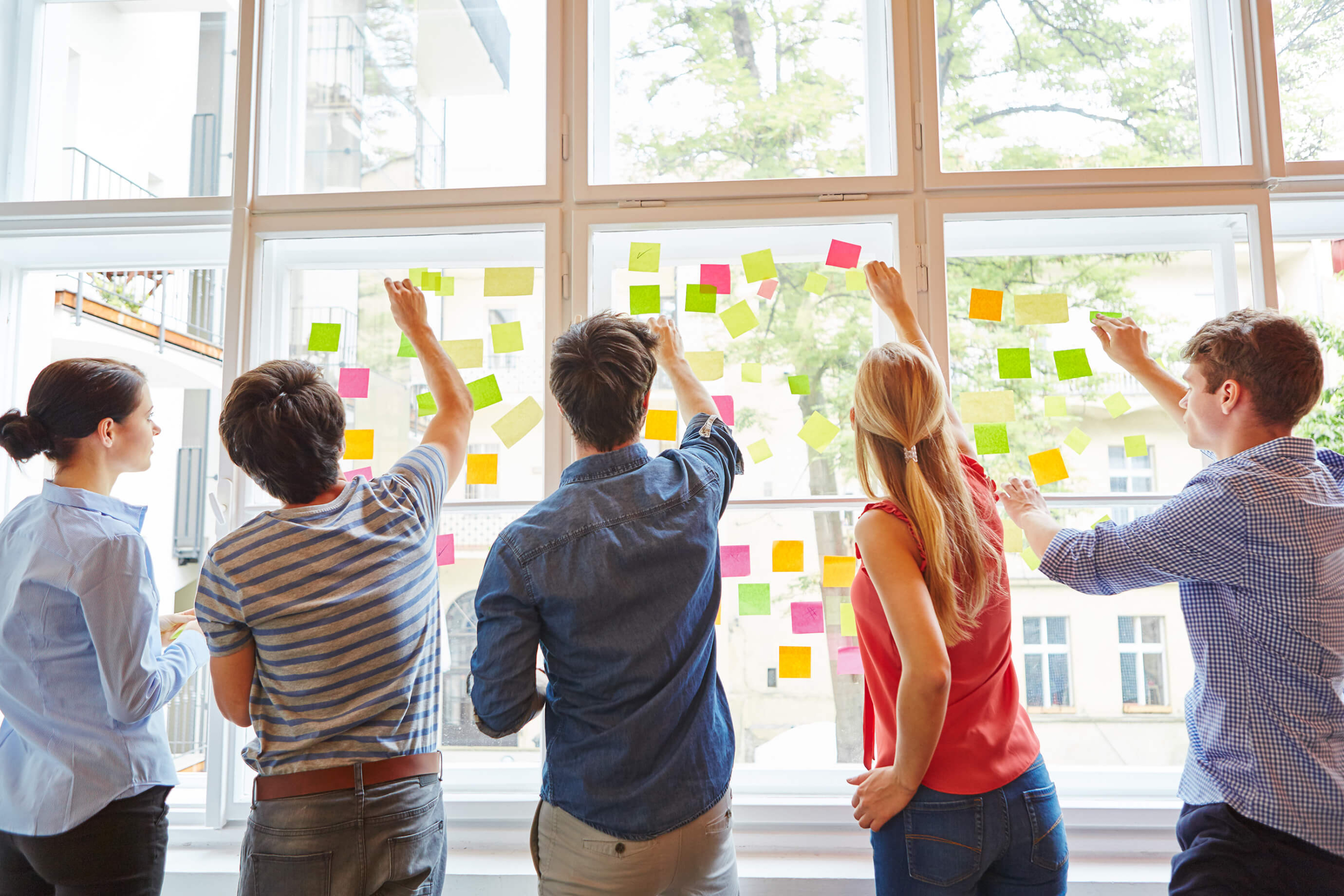 Team Members sticking Notes to Window Team Members sticking Notes to Window