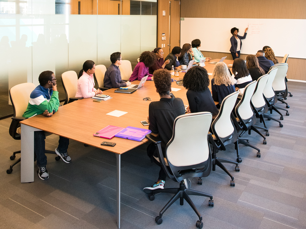 Woman Writing on Whiteboard in front of Office Team meeting