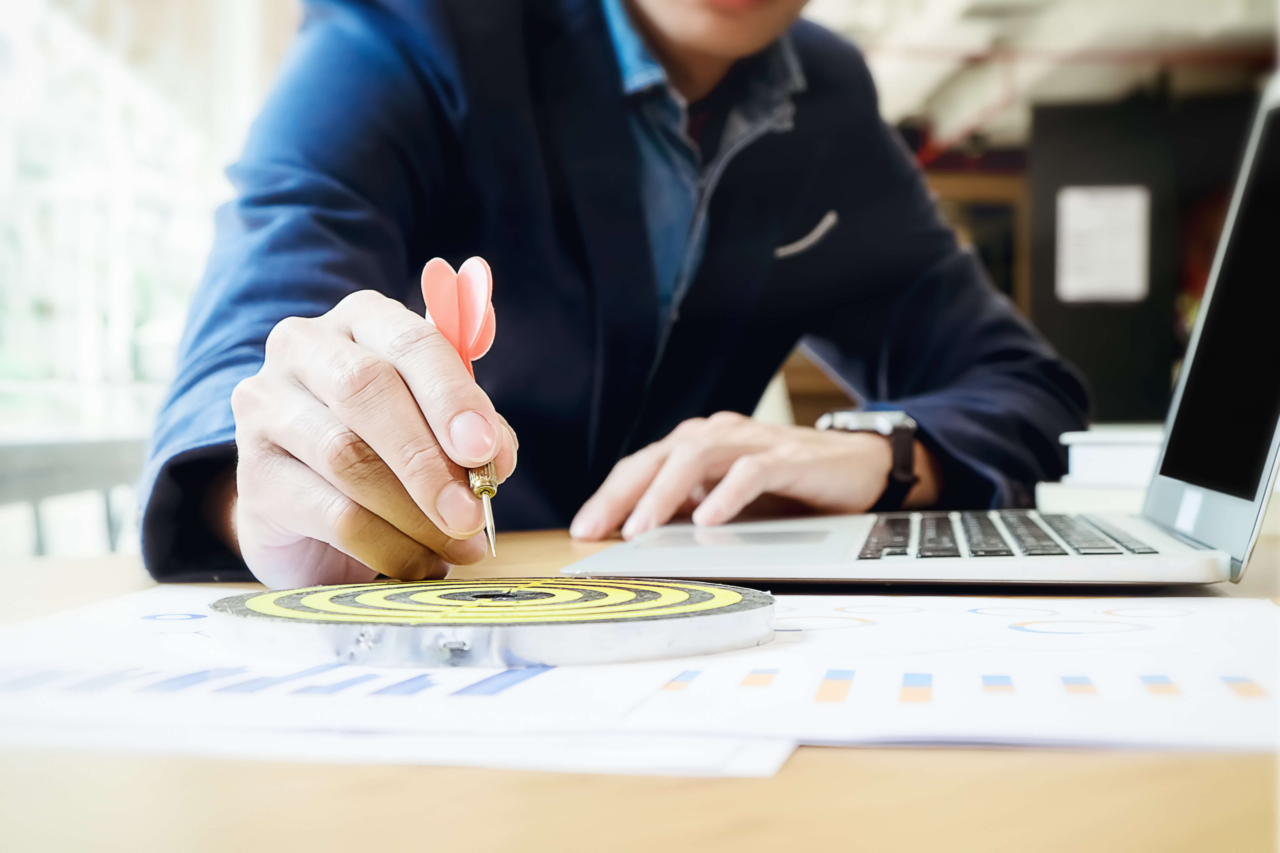 Man Sitting at Desk with Dart and Bullseye