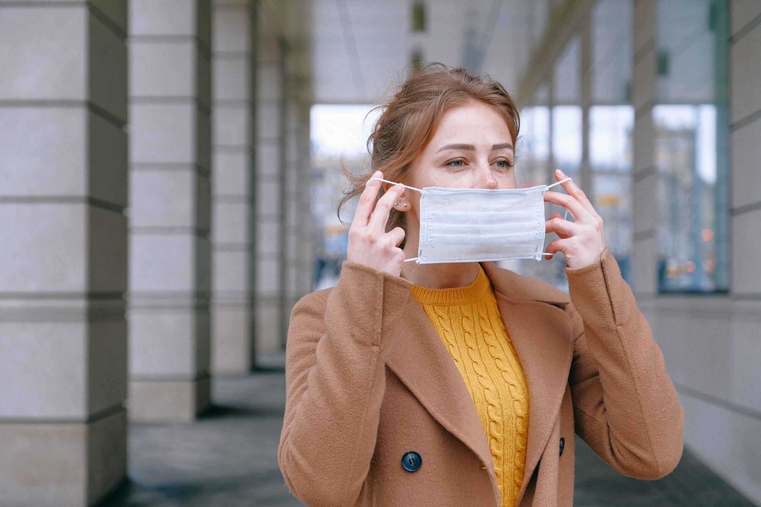 woman putting on face mask